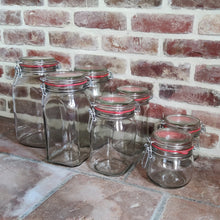 Load image into Gallery viewer, Corner view of clip-top jars with brick wall background
